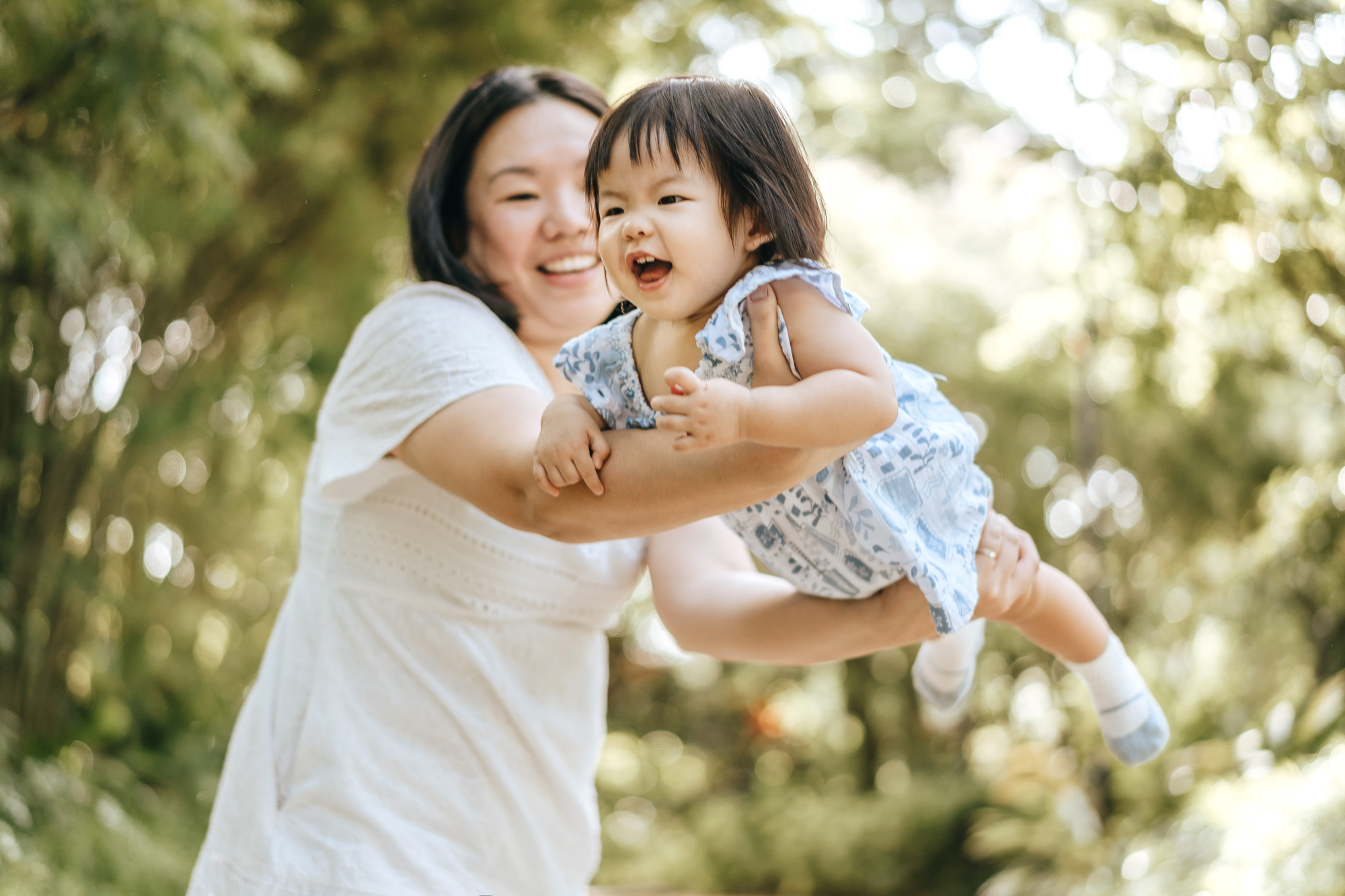 Happy baby girl felt like she's flying in mommy's hands.