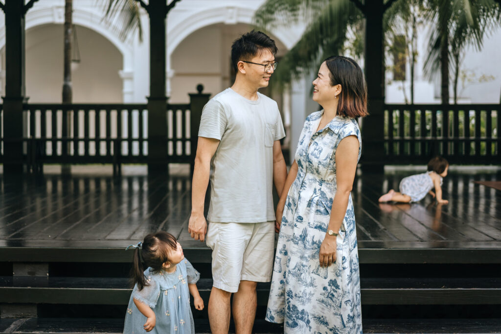 Photo of their cheeky daughter teasing mom and dad during their family photo shoot at the Raffles Hotel.