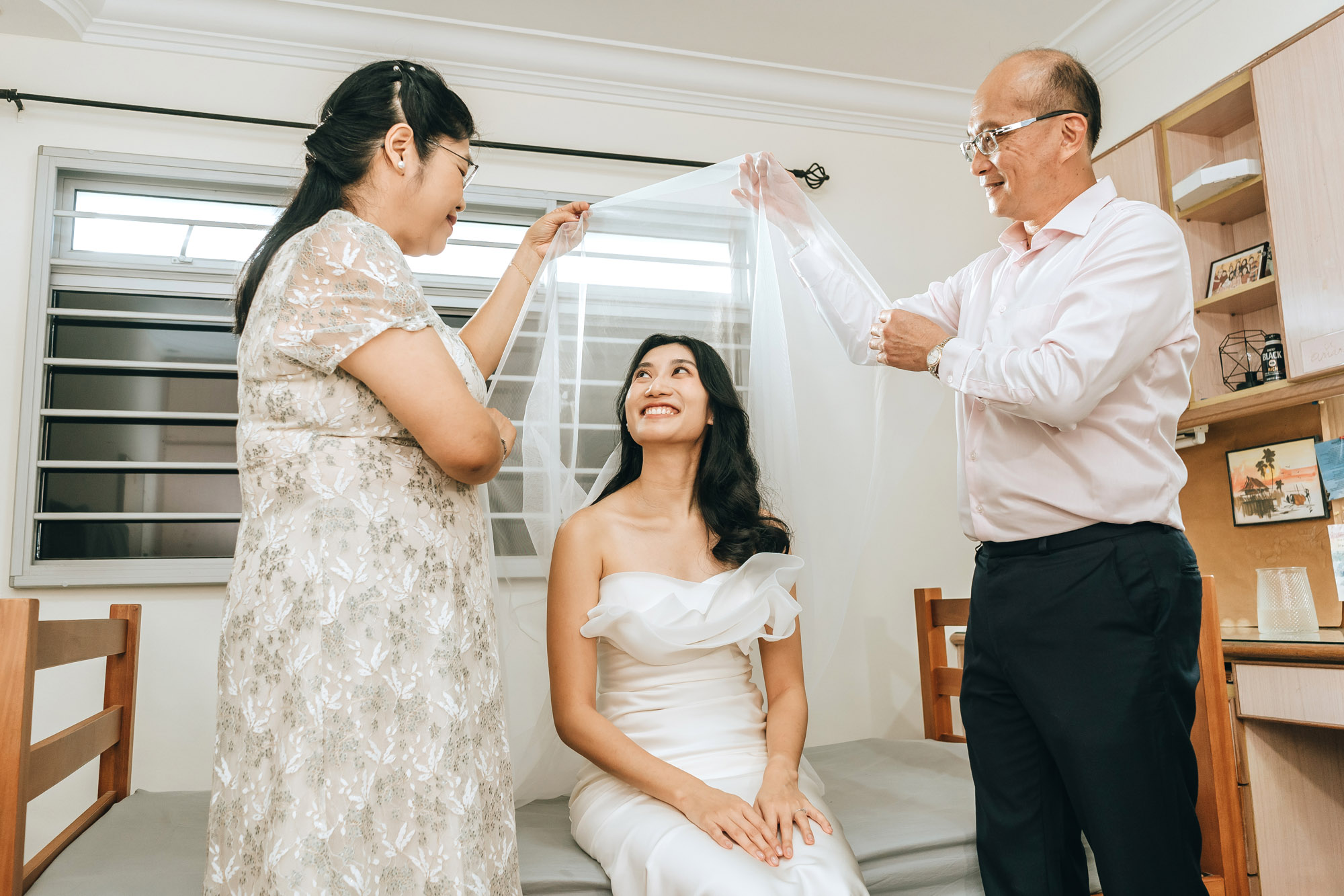 happy parents veiling the bride