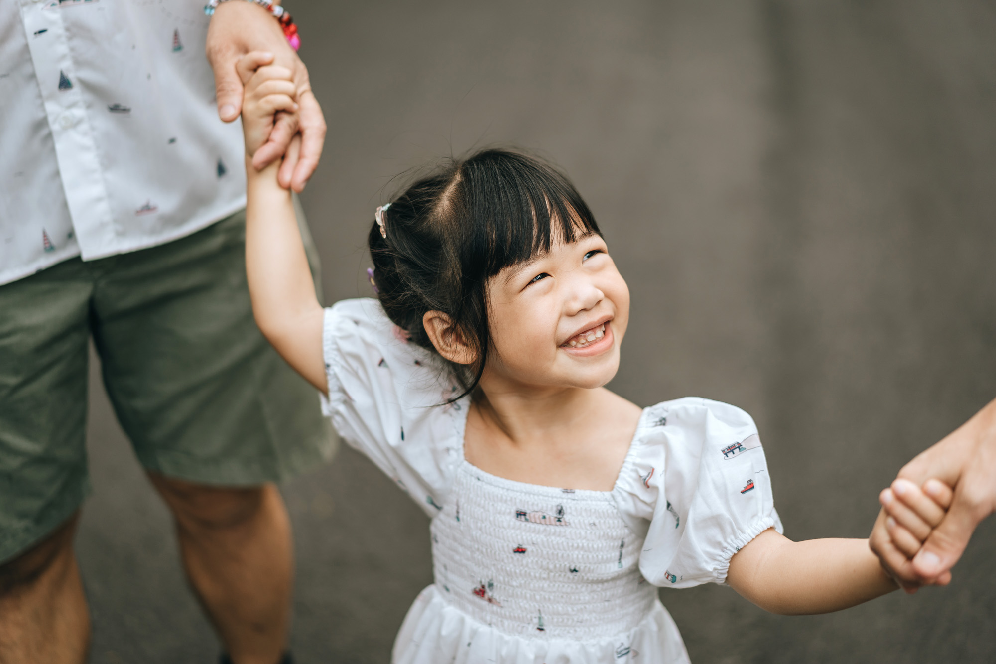 cute daughter holding parents' hands