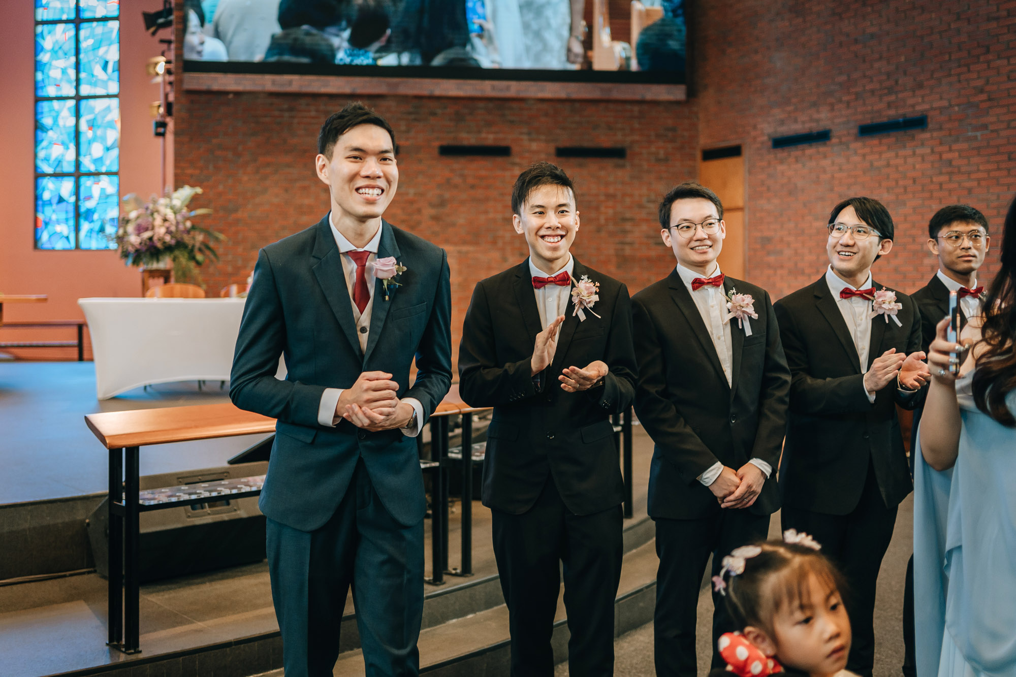 the groom and hi groomsmen clapping and cheering