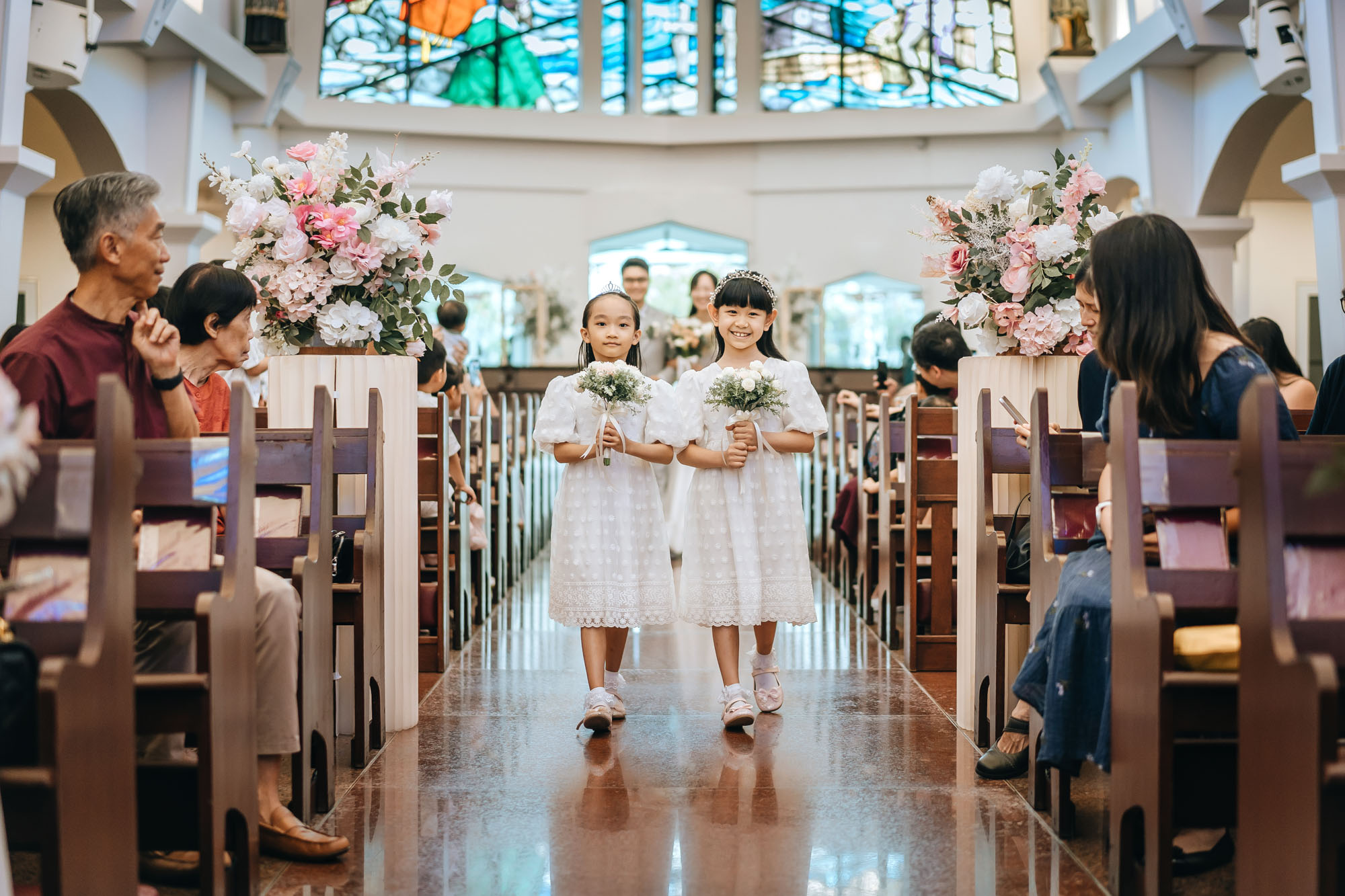 cute flower girls enter the church sanctuary