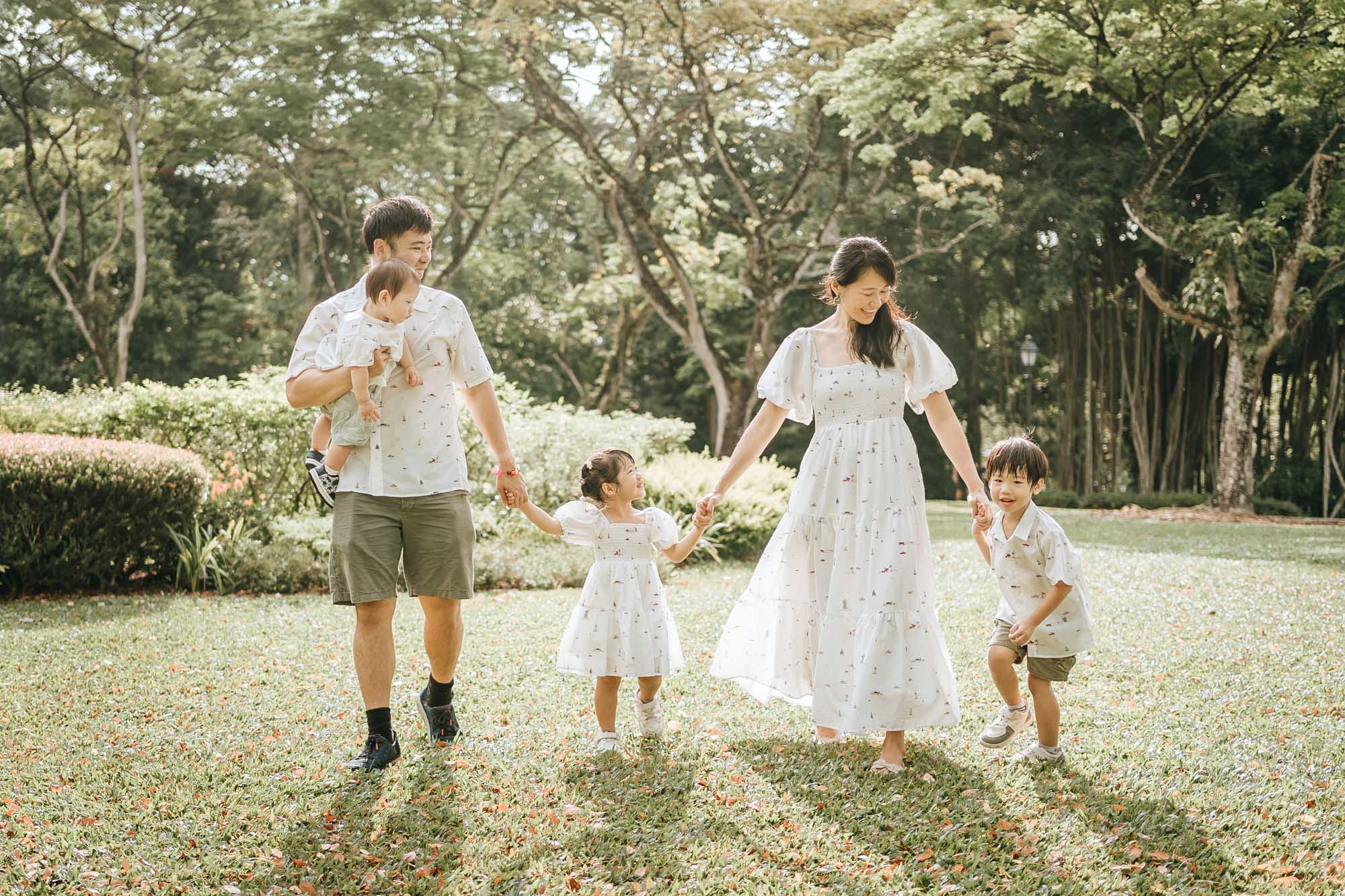 family holding hands and running on the lawn