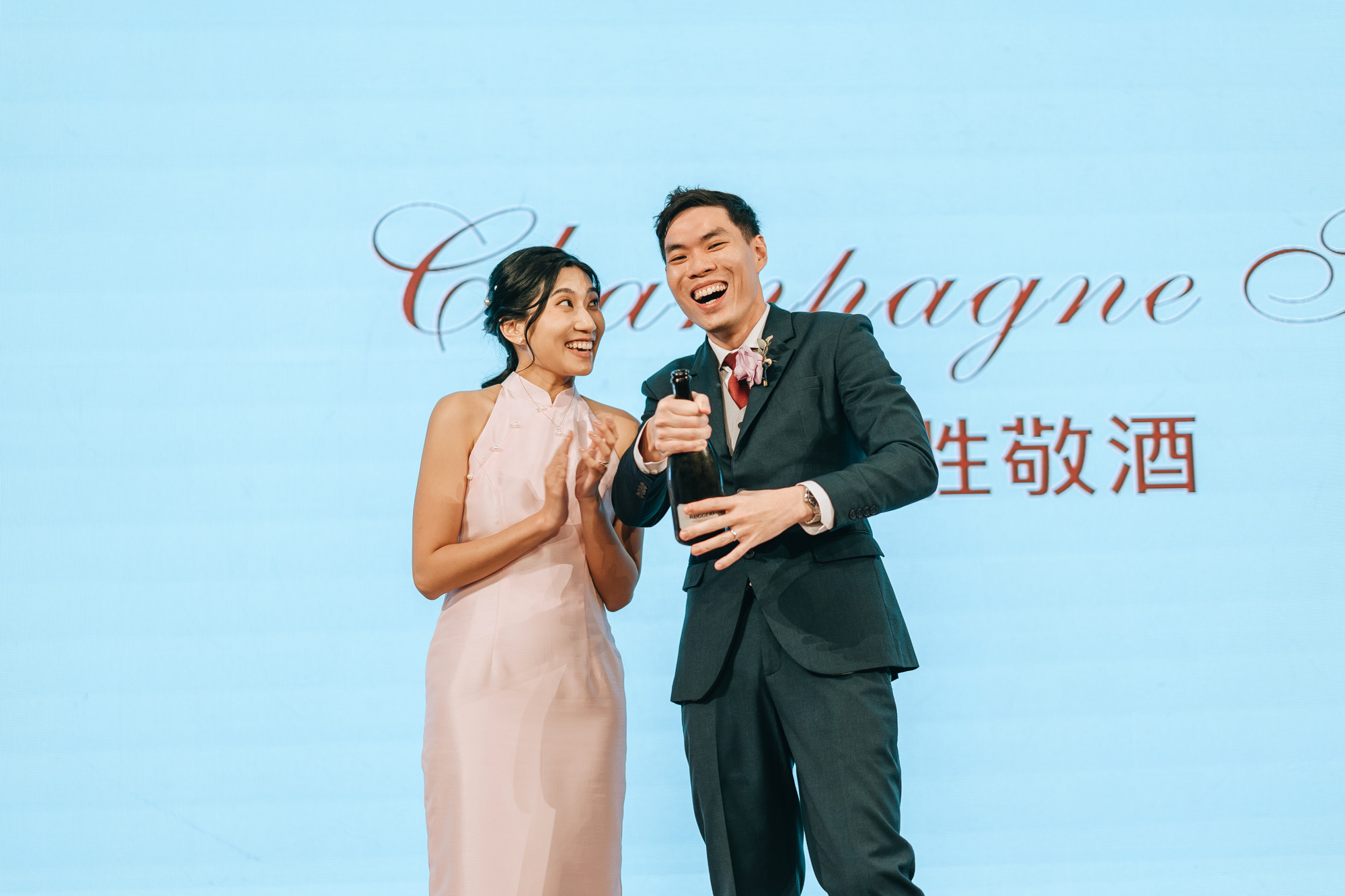 the wedding couple pops the champagne