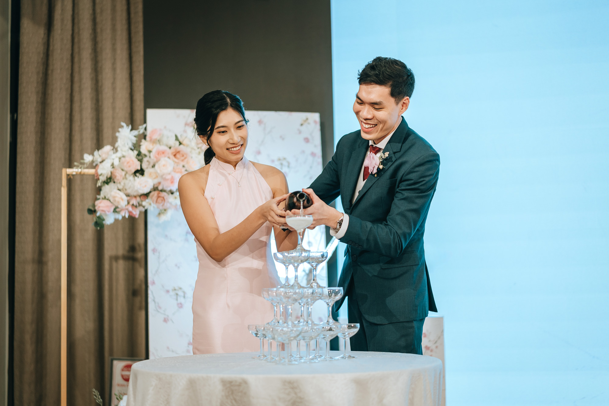 wedding couple pours the champagne down the glass tower