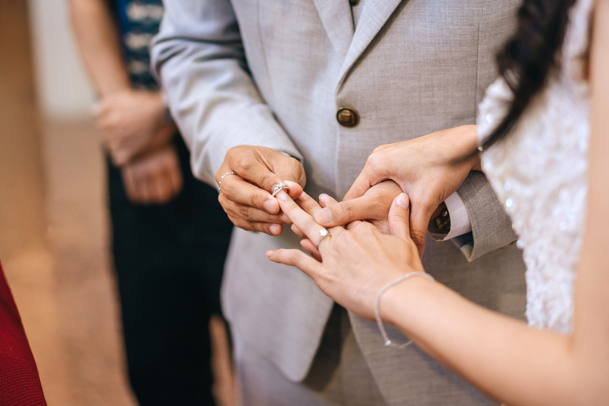 the groom putting on the ring for his bride