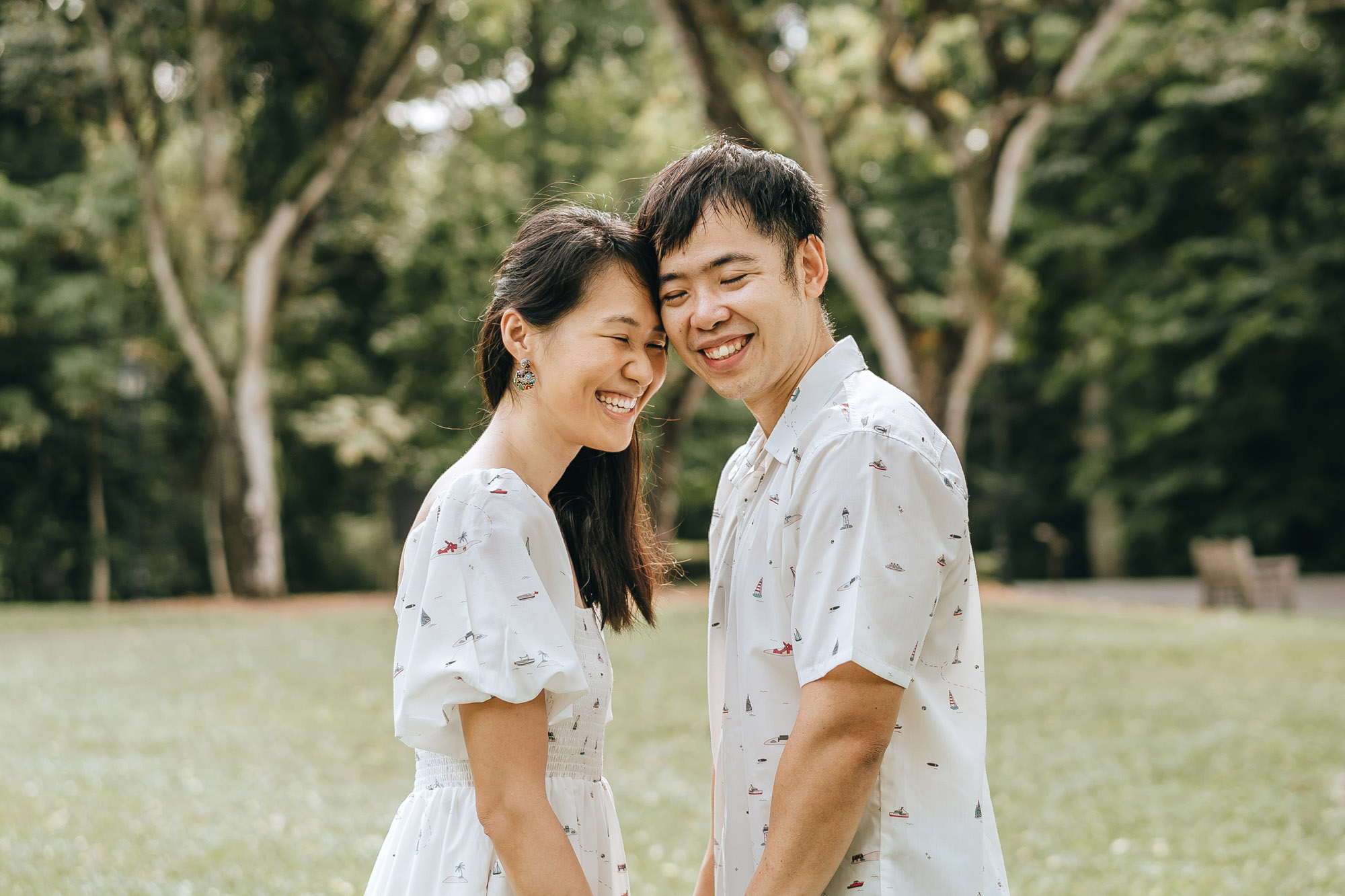 young parents smiling during family photo shoot at singapore botanic gardens